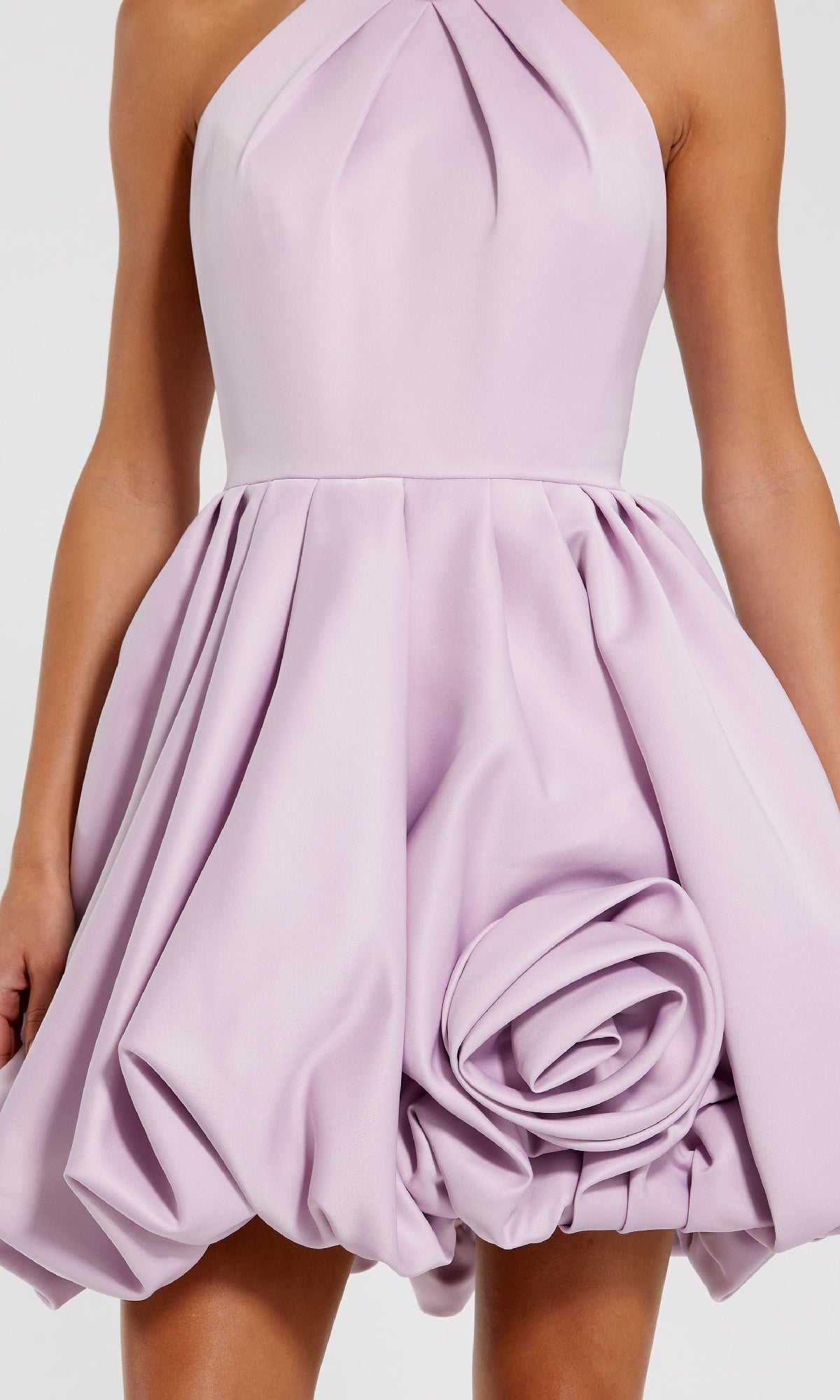 A person wearing the strapless Mac Duggal 20707 Short Bubble-Hem Party Dress in light purple satin, featuring a structured skirt and a large fabric rose detail.